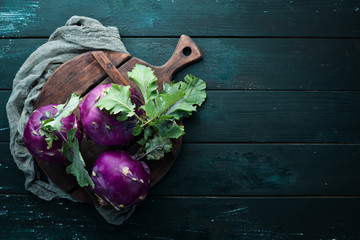 Purple kohlrabi cabbage. On a black background. Top view. Free space for your text.