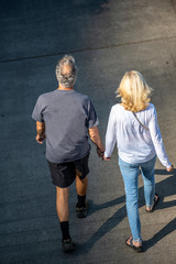 Elderly couple walking hiking holding hands