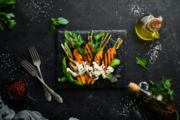 Fototapeta na wymiar Carrot grilled with feta cheese and parsley. Top view. Free space for your text.