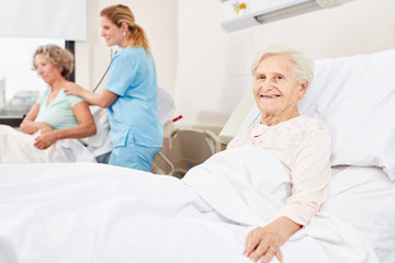 Fototapeta premium Glückliche Senior Frau im Krankenbett