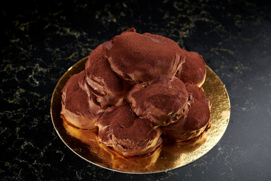 Italian chocolate profiteroles on a golden board