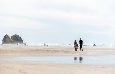 Young couple are walking along the shore of the Northwest Pacific