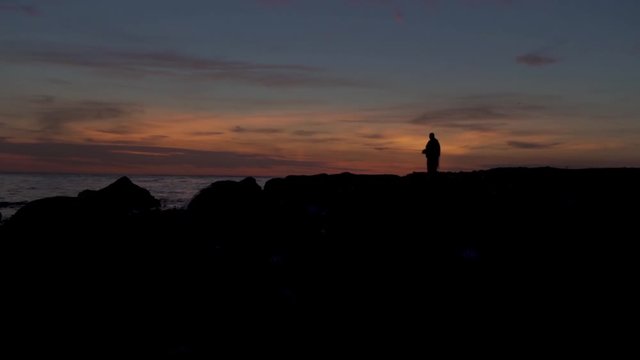 Scenic shot of a lone fisherman fishing on the shore of Langeland Island.