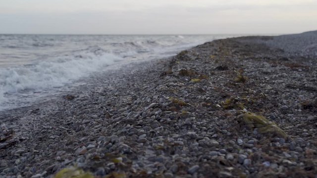Slow motion shot of sea waves crashing onto rocky beach.