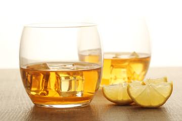 Two glasses with whiskey with ice cubes	