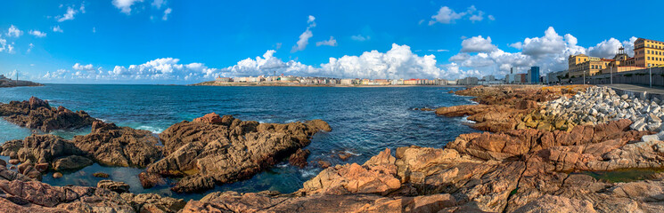 Panoramica de la playa de Riazon en A Coruña, con mar en calma en una tarde de verano con cielo con nubes y claros.