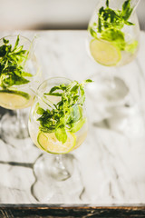 Hugo Sparkling wine cocktail with fresh mint and lime over white marble counter, top view, selective focus. Cold refreshing summer alcoholic drink