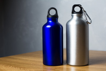 Two miscellaneous thermo bottle on the wooden table