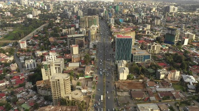 Tilted drone shot flying over traffic driving through busy main street in central Addis Ababa, Ethiopia's capital city
