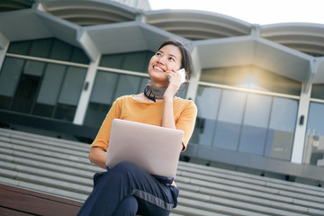 Fototapeta premium Beautiful Asian girl using computer laptop while she relaxing and sitting on staircase,startup,lifestyle concept.