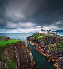 Fototapeta na wymiar Dark clouds move over the Fanad Head Lighthouse in Ireland