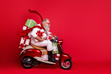 Profile side view of his he nice attractive trendy purposeful gray-haired man riding moto bike delivering pile stack purchase air wind blows isolated on bright vivid shine red background - obrazy, fototapety, plakaty
