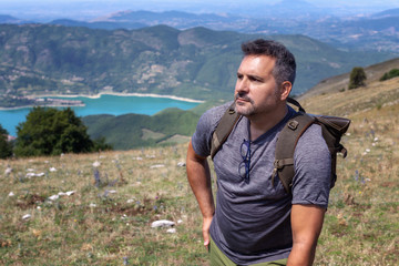 Hiker in the mountains and lake in the background