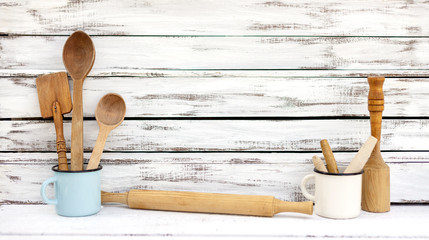 Vintage old kitchen utensils on a white wooden background.