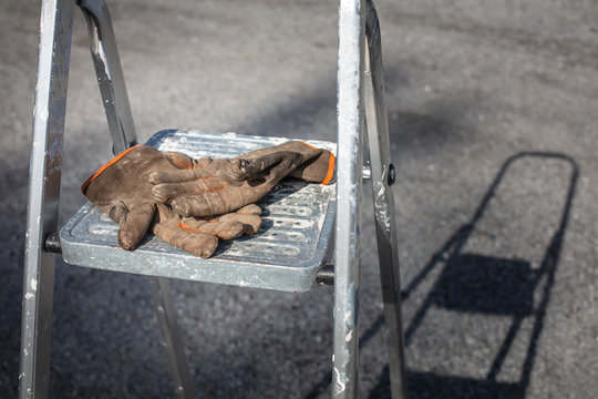 Worn and dirty worker gloves on ladders in Finland. The photograph depicts unemployment and the economic recession.