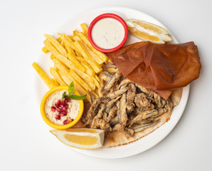 Grilled Sardines plate served with sauce, hummus dip and fries isolated on white background
