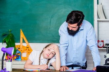 bearded man teacher with tired small girl in classroom. daughter study with father. Teachers day. back to school. knowledge day. Home schooling. education child development. feeling tired