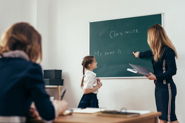 School lesson Teacher and pupil write on a blackboard
