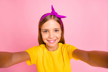 Self-portrait of her she nice attractive lovely shine winsome cheerful cheery pre-teen girl wearing yellow t-shirt enjoying holiday free time weekend isolated over pink pastel background