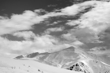 Black and white ski slope and sky with clouds in evening
