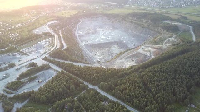green dense forests surround old mining factory with special technic in huge grey gravel quarry aerial view. Concept ecosystem disturbance