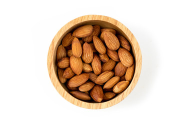 Close up of almonds nut seeds isolated in wooden bowl against top view on white background and clipping path.