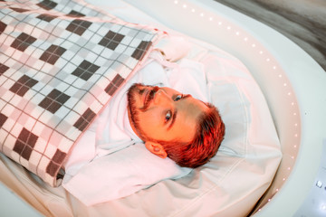 Wrapped man lying in the spa capsule