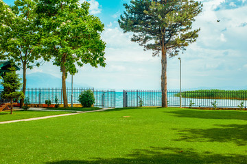 North macedonia. Ohrid. Path through green lawn to gate and lake in sunny day