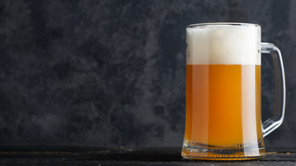 A mug of unfiltered wheat beer on a dark background with space for text or copyspace