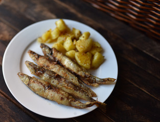 fried fish with potatoes on a wooden table top view
