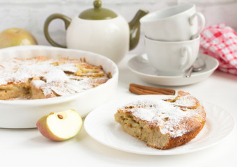 homemade Apple pie with cinnamon and utensils for tea on the table