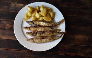 fried fish with potatoes on a wooden table top view