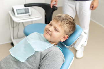 Blond little boy lays on dentist couch