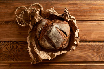 Fresh rye bread on the kitchen table. Wooden background.