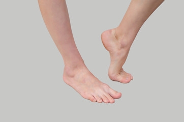 Beautiful female feet on gray background. Cosmetology, pedicure, foot care, foot fungus, treatment. Warm floor, relaxation
