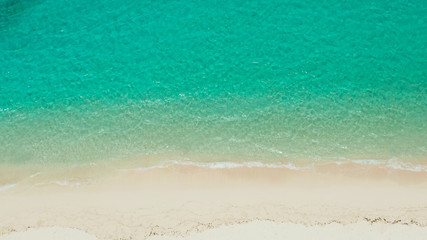 Tropical sandy beach with wave and turquoise water,copy space for text, aerial view. Sea water surface in lagoon. Transparent turquoise ocean water surface. Background texture