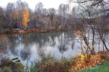 Autumn river with foliage and boat