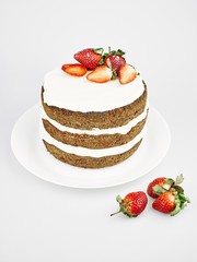 Homemade round one-piece layered cake on a white background close-up with strawberries