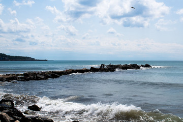 Seascape - light waves, stones on the embankment, they say, white clouds