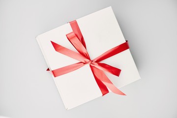 Closeup of cakes in white boxes tied with a red ribbon