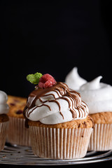 Delicious flavored cupcake with raspberries, white cream, and chocolate icing.