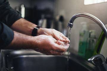 Man washing hand with kitchen sink faucet
