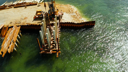 Pile driving machine in construction site.The bridge under construction across the bay and...