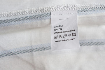 White laundry care washing instructions clothes label on rayon shirt