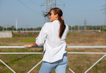 Beautiful young girl walking in industrial landscapes.