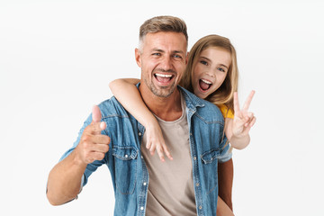 Image of attractive caucasian family father and daughter piggybacking and gesturing at camera - obrazy, fototapety, plakaty