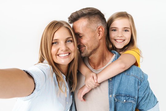 Image of happy caucasian family woman and man with little girl smiling and taking selfie photo together