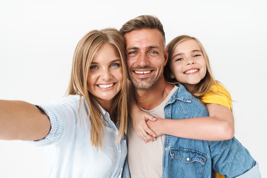 Image of amusing caucasian family woman and man with little girl smiling and taking selfie photo together