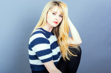 Portrait of an attractive woman, shot in the studio against a grey background