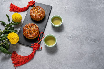 Chinese Mid-Autumn Festival cuisine, mooncakes and tea on a cement textured background